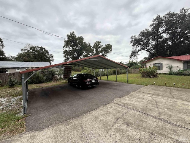 view of vehicle parking with a lawn and a carport