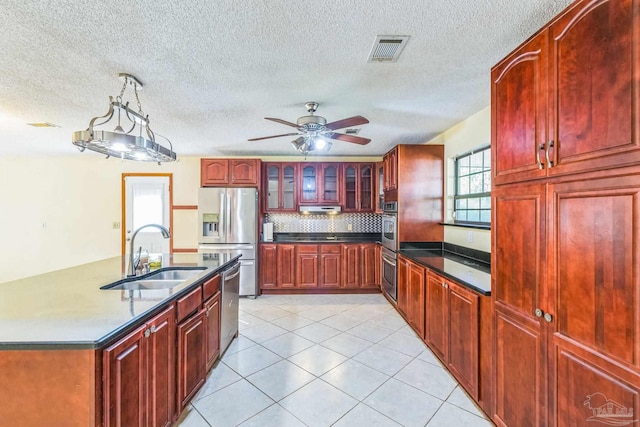 kitchen featuring decorative backsplash, appliances with stainless steel finishes, ceiling fan, sink, and light tile patterned floors