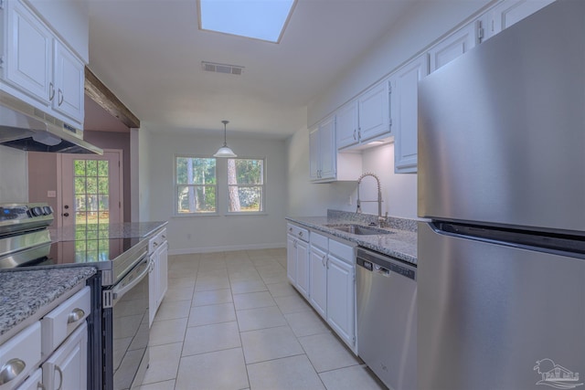 kitchen with light tile patterned flooring, appliances with stainless steel finishes, white cabinetry, sink, and hanging light fixtures