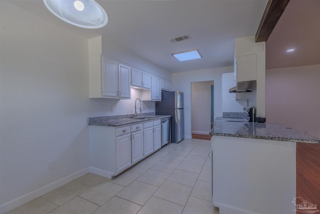 kitchen with sink, white cabinetry, light tile patterned floors, appliances with stainless steel finishes, and kitchen peninsula