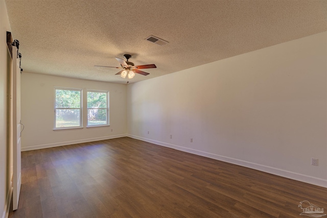 empty room featuring dark hardwood / wood-style flooring, a textured ceiling, and ceiling fan