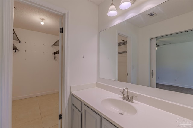 bathroom featuring vanity, ceiling fan, tile patterned floors, and a textured ceiling