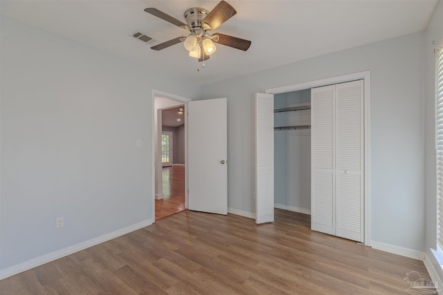 unfurnished bedroom with ceiling fan, a closet, and light wood-type flooring