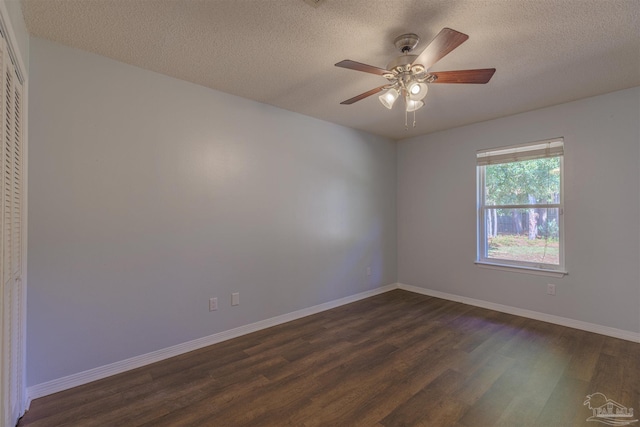 empty room with ceiling fan, dark wood-type flooring, and a textured ceiling