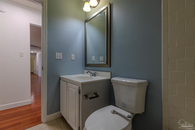 bathroom with tile patterned flooring, vanity, and toilet