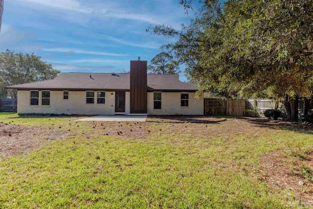 rear view of house featuring a yard and a patio