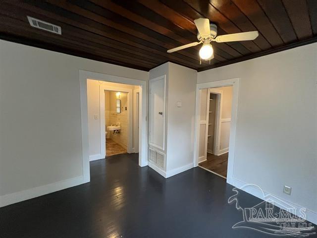 empty room with wood ceiling, baseboards, visible vents, and a ceiling fan