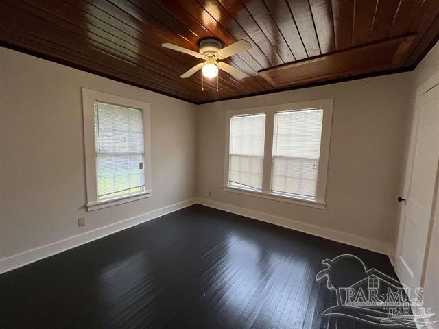 empty room with wooden ceiling, plenty of natural light, and baseboards