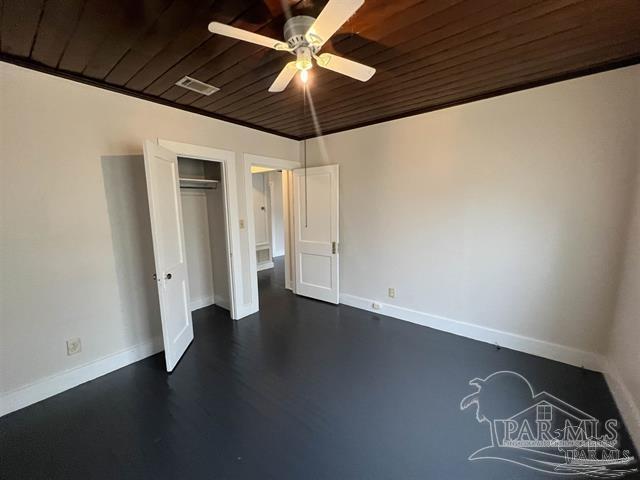 unfurnished bedroom with a closet, visible vents, wood ceiling, ceiling fan, and baseboards