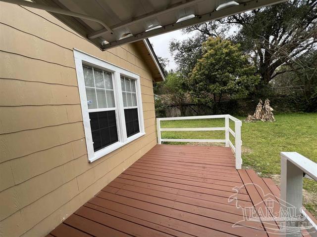 wooden terrace with a lawn