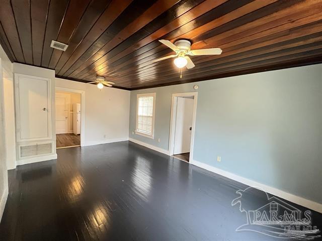 spare room featuring visible vents, wood ceiling, ceiling fan, wood finished floors, and baseboards