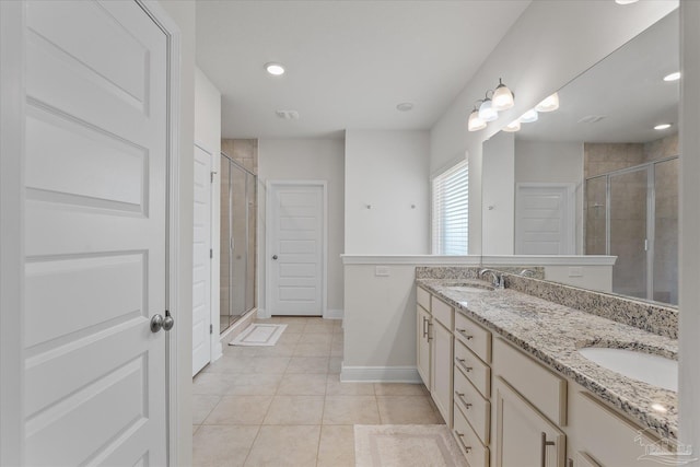 bathroom with tile patterned flooring, vanity, and walk in shower