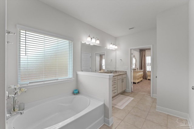 bathroom featuring vanity, plenty of natural light, a bath, and tile patterned floors