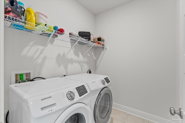 laundry area with light tile patterned flooring and washer and dryer