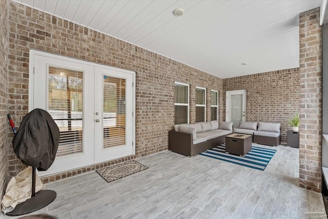 view of patio / terrace with a wooden deck, an outdoor living space with a fire pit, and french doors