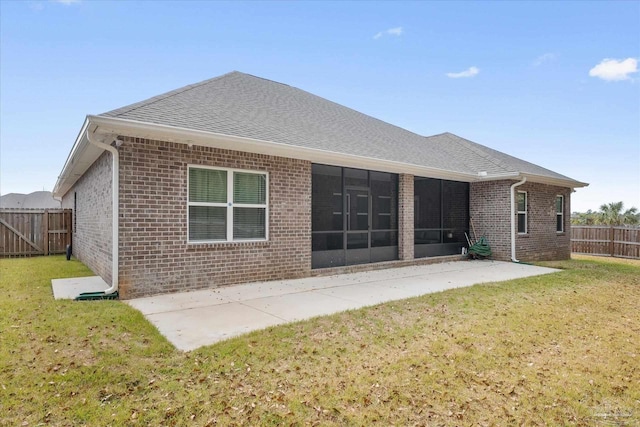 rear view of property with a yard, a patio area, and a sunroom