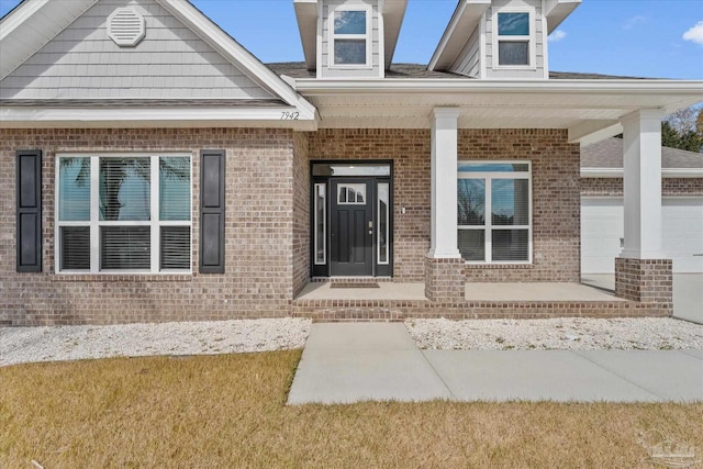 doorway to property featuring a garage and a porch