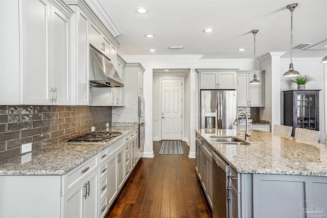 kitchen featuring crown molding, baseboards, under cabinet range hood, a sink, and stainless steel appliances