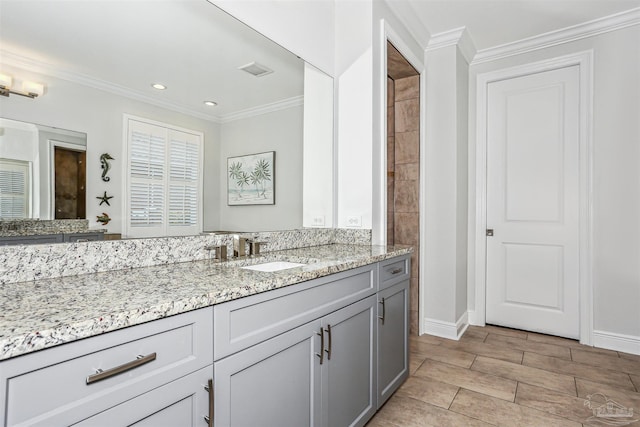 bathroom with crown molding, vanity, recessed lighting, baseboards, and visible vents