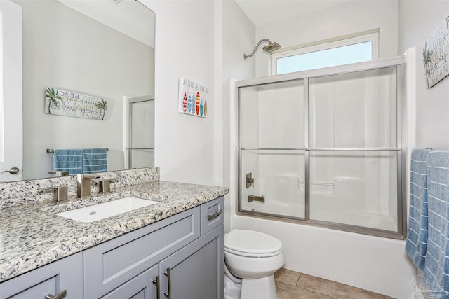 full bath featuring vanity, tile patterned flooring, toilet, and shower / bath combination with glass door