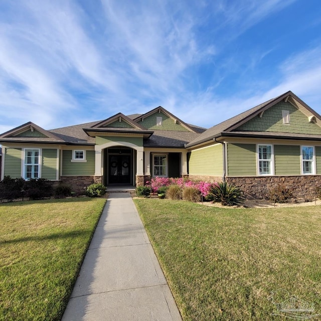 craftsman house featuring a front yard and stone siding