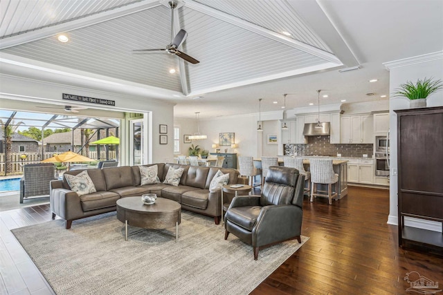 living area featuring recessed lighting, ceiling fan, ornamental molding, and dark wood-type flooring