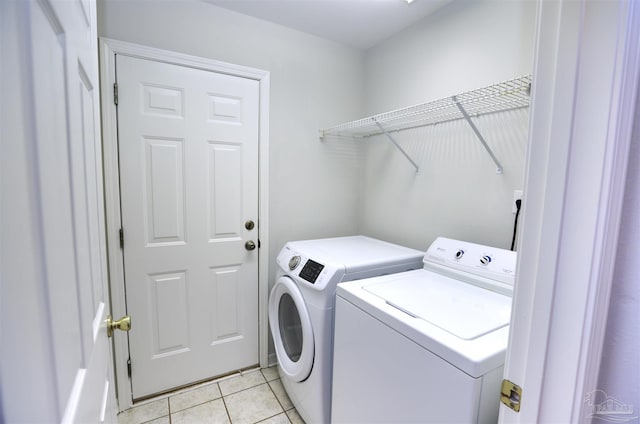 washroom featuring washer and clothes dryer and light tile patterned flooring