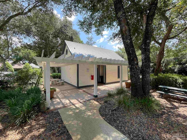 rear view of property featuring a pergola and a patio area