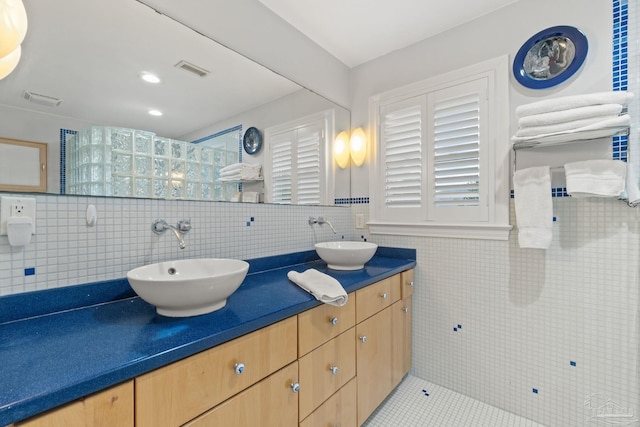 bathroom featuring tile patterned flooring, vanity, and tile walls