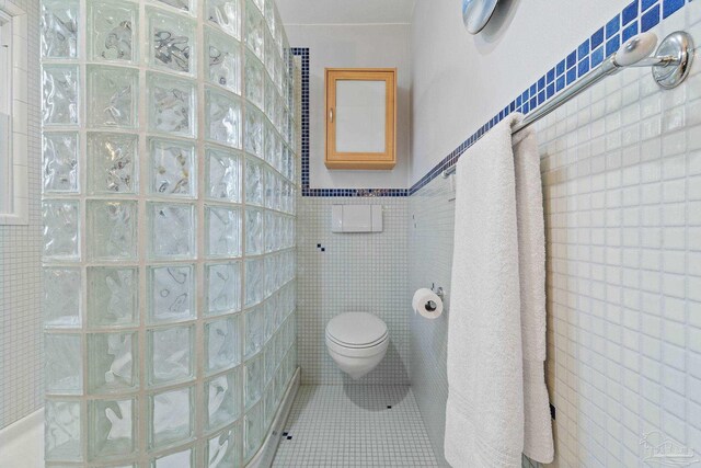 bathroom featuring a shower and tile walls