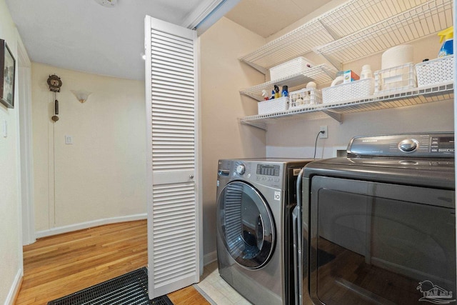 washroom with light wood-type flooring and washing machine and dryer