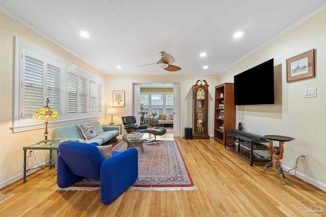 living room featuring ceiling fan, light wood-type flooring, and ornamental molding