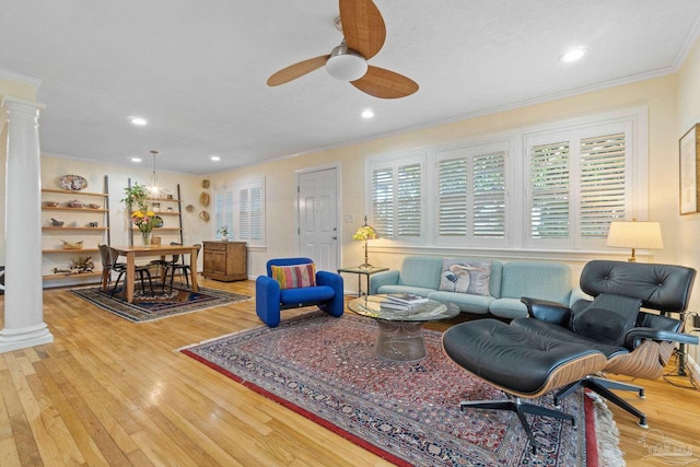 living room with light hardwood / wood-style floors, ornate columns, ceiling fan, and crown molding