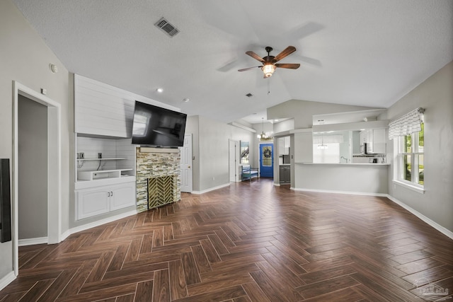 unfurnished living room with baseboards, a large fireplace, ceiling fan with notable chandelier, and vaulted ceiling