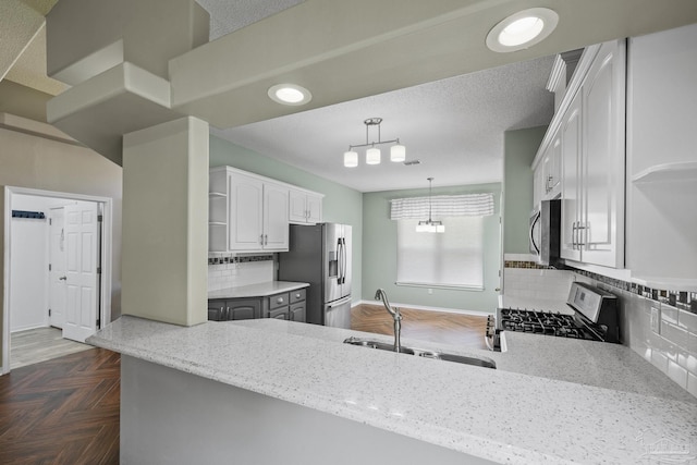 kitchen featuring stainless steel appliances, backsplash, white cabinets, and a sink