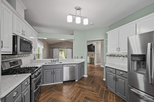 kitchen with gray cabinets, stainless steel appliances, white cabinets, and a sink