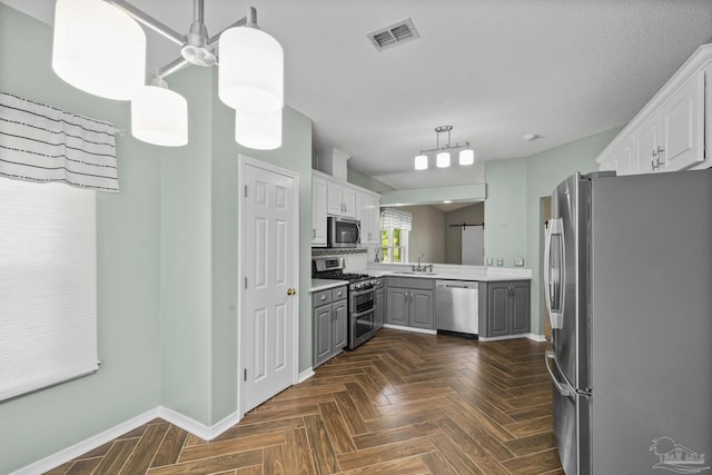 kitchen featuring a sink, stainless steel appliances, light countertops, baseboards, and gray cabinets