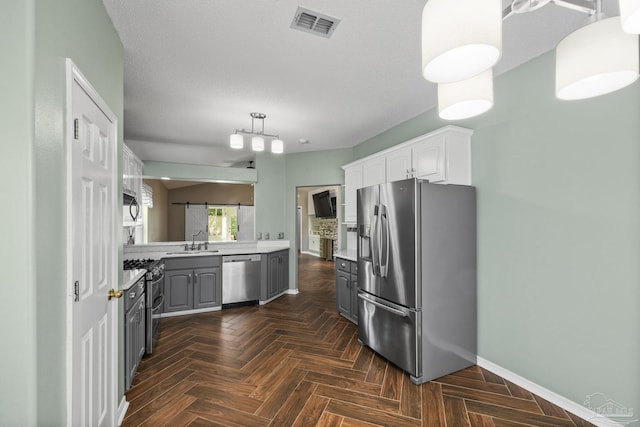 kitchen with a sink, visible vents, stainless steel appliances, light countertops, and baseboards