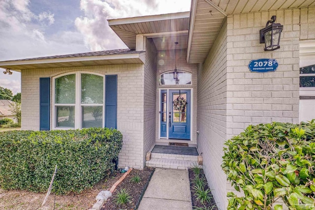 property entrance featuring brick siding