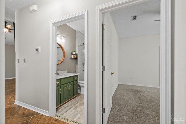 hall featuring a sink, visible vents, and baseboards