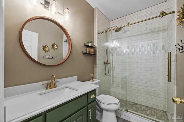 bathroom featuring toilet, a textured ceiling, a shower stall, and vanity