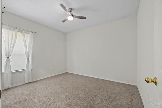 carpeted spare room with baseboards and ceiling fan