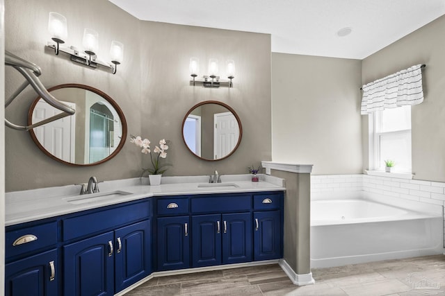 full bath with a garden tub, double vanity, a sink, and wood finished floors