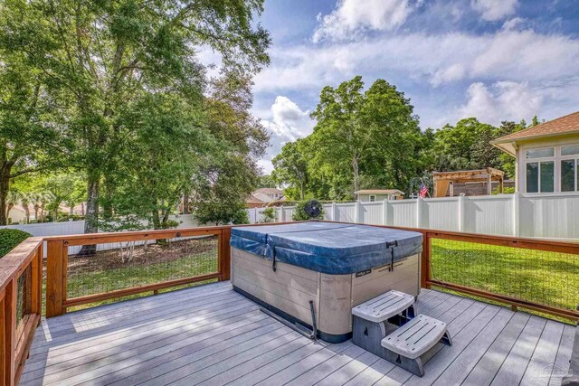wooden deck featuring a fenced backyard and a hot tub