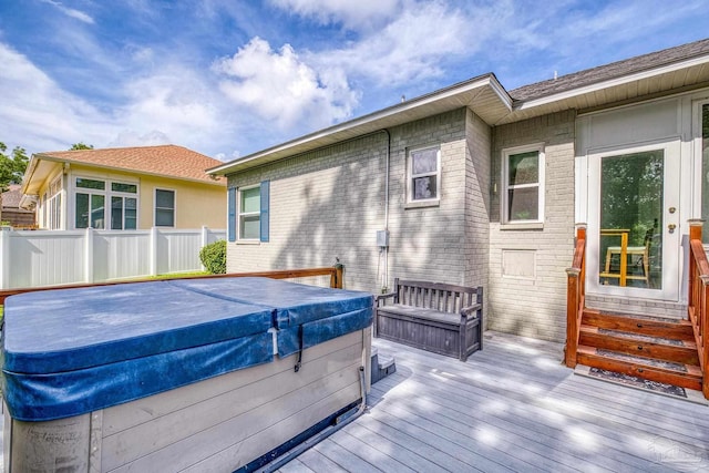 deck with fence and a hot tub