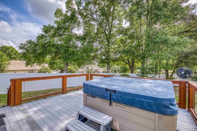 deck with a fenced backyard and a hot tub