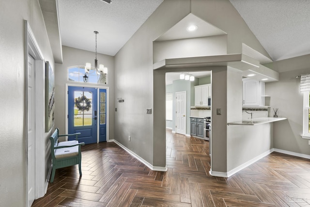 entrance foyer featuring baseboards, high vaulted ceiling, and an inviting chandelier