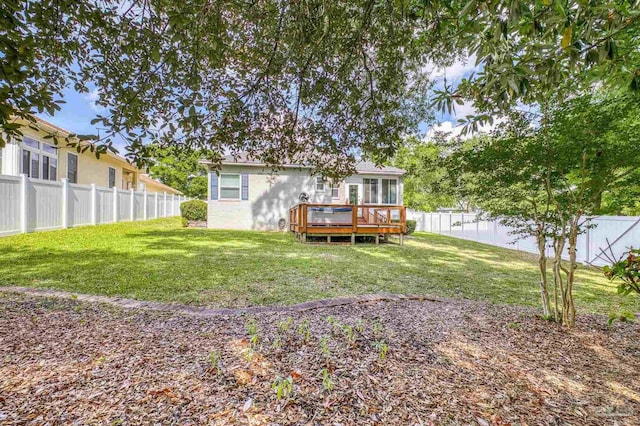 back of house featuring a deck, a yard, and a fenced backyard