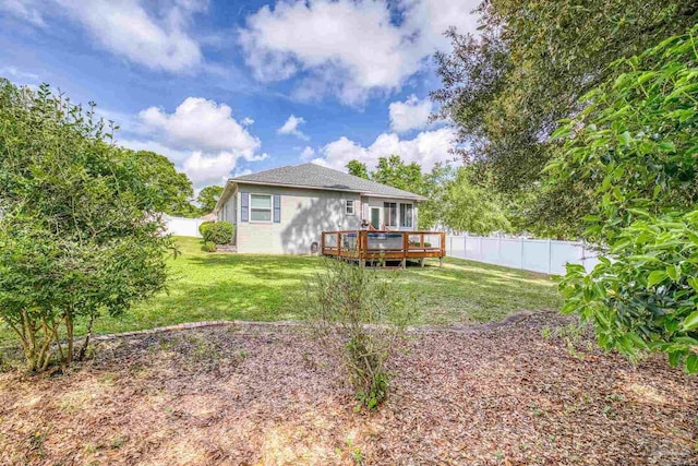 back of house featuring a wooden deck, a yard, and a fenced backyard