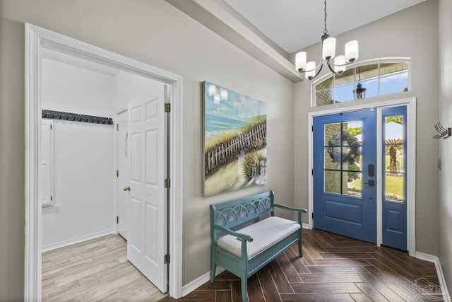 foyer entrance featuring an inviting chandelier and baseboards